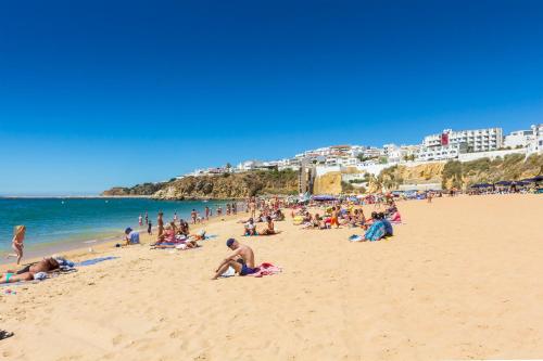 un grupo de personas en una playa cerca del océano en Vila Recife Hotel, en Albufeira