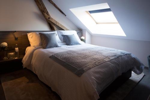 a bedroom with a large bed with a skylight at Etoile de Pompadour in Arnac-Pompadour