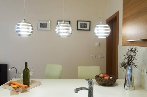 a kitchen with three pendant lights above a sink at Apartments Pri nas in Kobarid