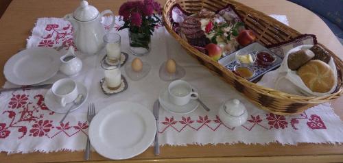 a table with white dishes and a basket of food at App Unterhoezlhof in Valdaora
