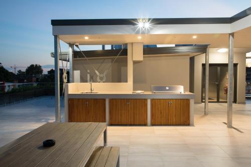 an outdoor kitchen with a table on a patio at Studio 8 Residences - Adults Only in Sydney