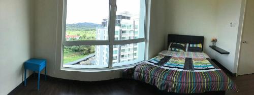 Un pat sau paturi într-o cameră la Sandakan Spacious and Comfortable Pool View Condo