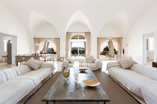 un soggiorno con 2 divani bianchi e un tavolo di Casa Murredda by BarbarHouse a Ceglie Messapica