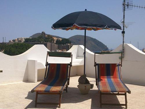 due sedie sotto un ombrellone su un tetto di Villa Alba Chiara a Città di Lipari
