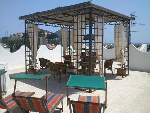 un gazebo con sedie e tavoli su un patio di Villa Alba Chiara a Città di Lipari