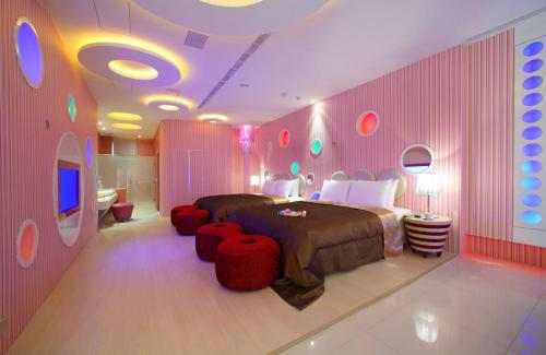 a bedroom with a bed and red ottomans in it at Le chateau Motel in Zhushan