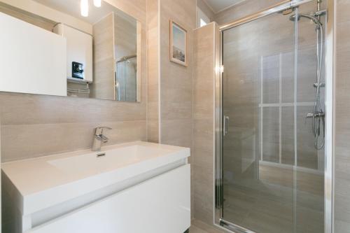 une salle de bain avec un lavabo et une douche dans l'établissement Assas-Vavin Appartements, à Paris