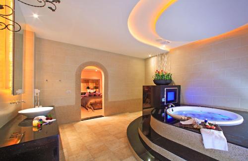 Le chateau Motel في تشوشان: حمام كبير مع حوض استحمام وغرفة نوم