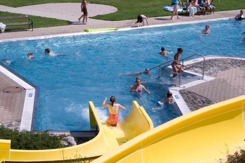 a group of people playing in a swimming pool at Das kleine Berghotel in Liesing