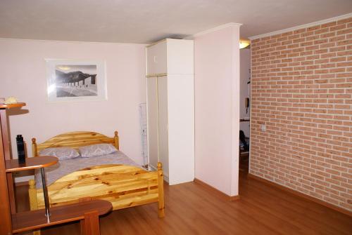 1 dormitorio con cama y pared de ladrillo en Studio Na Pervom Etazhe, en Moscú