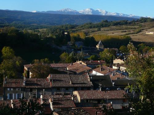 a village in the mountains with snow covered mountains at Hôtel De France in Chalabre
