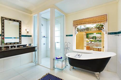 a bathroom with a large tub and a window at The Oberoi Udaivilas Udaipur in Udaipur