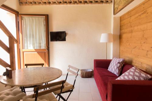 a living room with a red couch and a table at Chiesa Ignano 1778 in Marzabotto