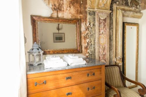 a wooden dresser with a mirror and towels on it at Chiesa Ignano 1778 in Marzabotto