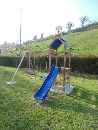 a playground with a slide in a field at Bigotti in Fano