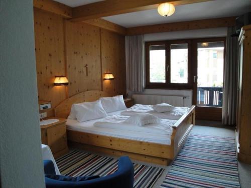 a bedroom with a large bed and a desk at Gästehaus Brindlinger in Zell am Ziller