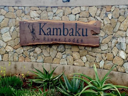 a sign for kambaku river lodge on a stone wall at Kambaku River Lodge in Malelane
