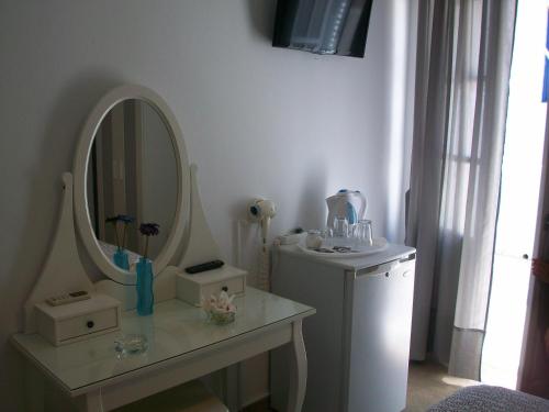 a bathroom with a mirror and a table with a sink at Guesthouse Corali in Hydra