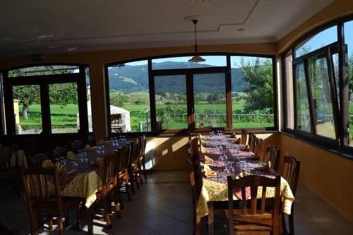 a dining room with tables and chairs and windows at Agriturismo La Gemma del Parco in Mormanno