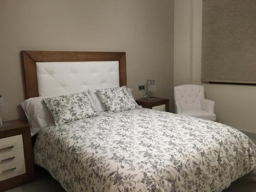 ロンダにあるNew Apartments Rondaのベッドルーム1室(ベッド1台、椅子付)