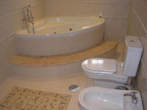 a bathroom with a tub and a toilet and a sink at Villa d'Arcos in Arcos