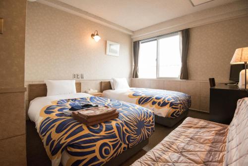 Kyoto Travellers Inn tesisinde bir odada yatak veya yataklar