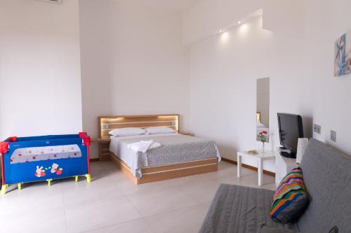 a bedroom with a bed and a tv in it at Lalena's Garden in Portopalo
