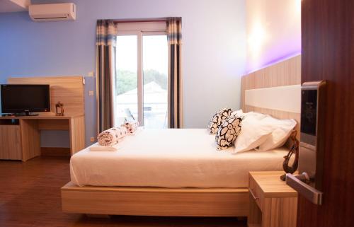 een slaapkamer met een groot bed en een raam bij Hotel Blue Moon in Ulcinj