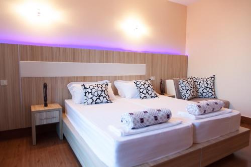 two beds in a room with purple lights at Hotel Blue Moon in Ulcinj