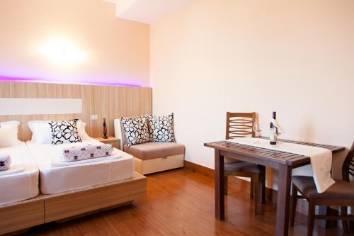 a bedroom with a bed and a desk and a table at Hotel Blue Moon in Ulcinj