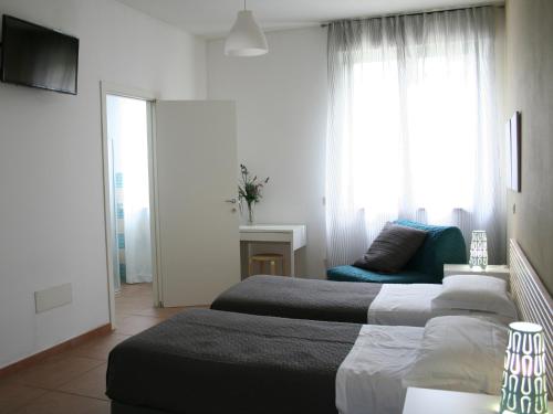 a hotel room with two beds and a couch at Guest House Parco del Mulino in Livorno