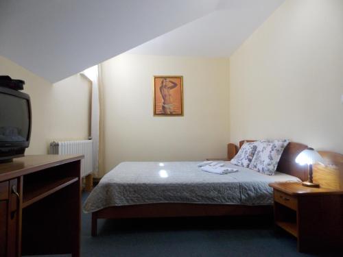a small bedroom with a bed and a tv at Boeritza Hotel Complex in Vladaya