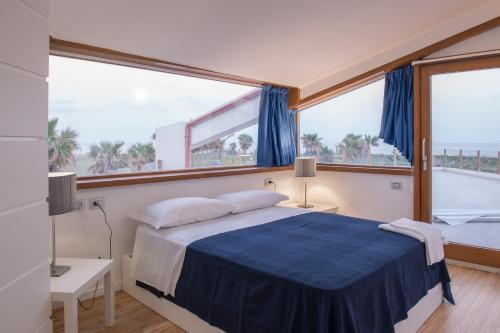 ein Schlafzimmer mit einem Bett und einem großen Fenster in der Unterkunft Lalena's Garden in Portopalo