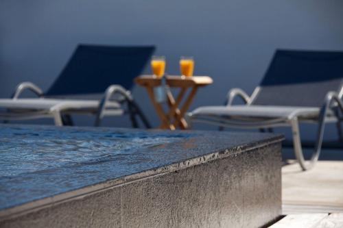 two chairs and two orange glasses on a table at Lodge Sainte Helene Adult only in Saintes-Maries-de-la-Mer