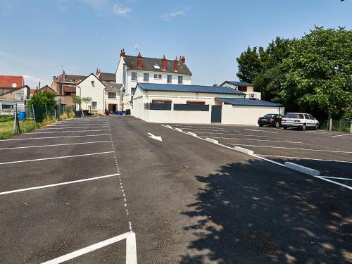 a parking lot with a car parked in it at Logis hôtel Au Relais Nivernais in Nevers