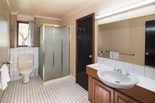 a bathroom with a sink and a toilet and a mirror at Trastevere Cowaramup Farm House in Cowaramup