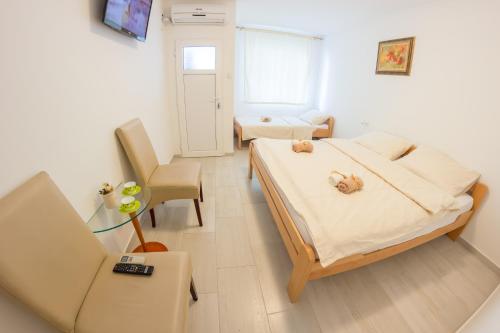 a bedroom with a bed with two teddy bears on it at Villa Ami in Novi Sad