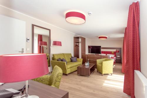 a living room with yellow chairs and a living room at Thalhauser Mühle Hotel-Restaurant in Thalhausen