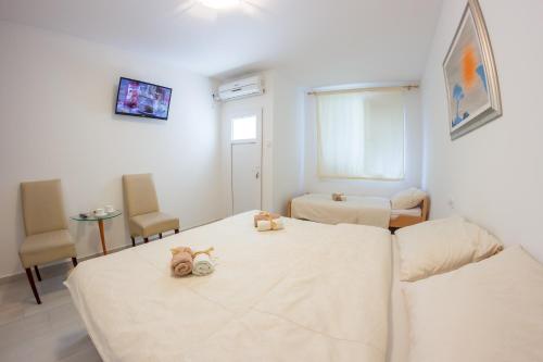 a room with a bed with two stuffed animals on it at Villa Ami in Novi Sad