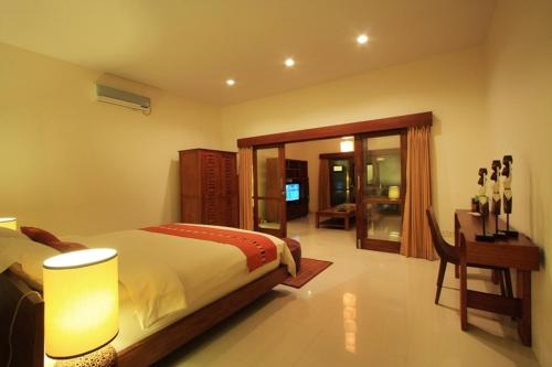 1 dormitorio con cama, mesa y escritorio en Ananda Private Villa, en Gili Trawangan