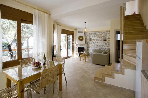 eine Küche und ein Wohnzimmer mit einem Tisch und Stühlen in der Unterkunft Villas Zoe in Skiathos-Stadt