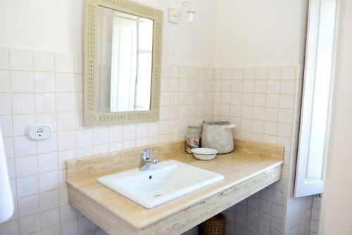 y baño con lavabo y espejo. en Hotel Rural El Solar del Mazo, en Rada