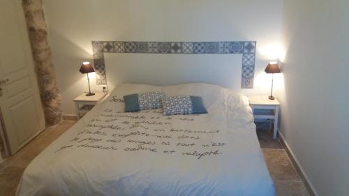 a bedroom with a bed with writing on it at Bastide Provençale Les Mûriers d'Engaspaty in Seillans