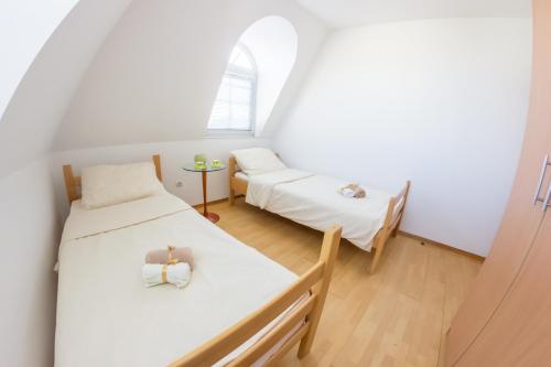 a small room with two beds and a window at Villa Ami in Novi Sad