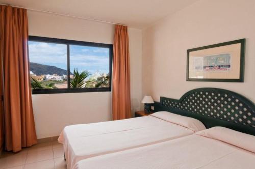 a hotel room with a bed and a large window at Apartamentos Baja Del Secreto in Valle Gran Rey