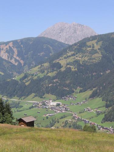 a green valley with a town in the middle of a mountain at Das kleine Berghotel in Liesing