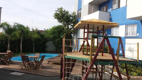 einen Spielplatz vor einem Gebäude mit Pool in der Unterkunft Apartamento linda vista para o mar Penha Parque Beto Carrero in Penha