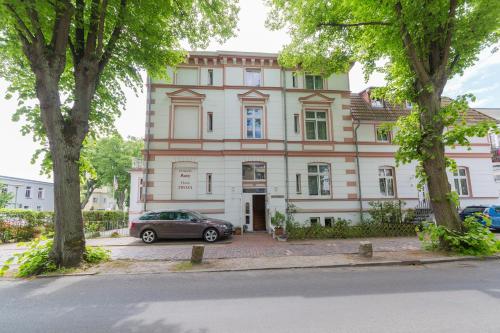 a building with a car parked in front of it at Haus Troja in Warnemünde