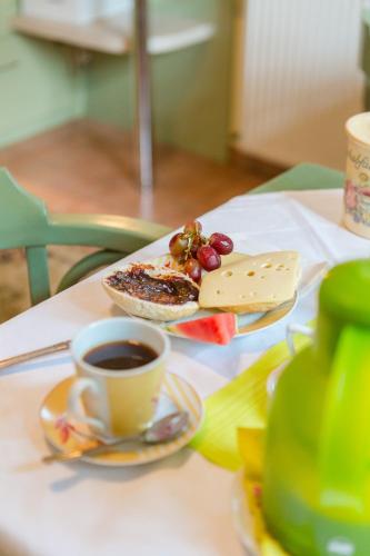 a plate of food and a cup of coffee on a table at Haus Troja in Warnemünde