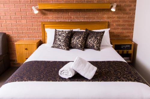a bedroom with a bed with two towels on it at Advance Motel in Wangaratta